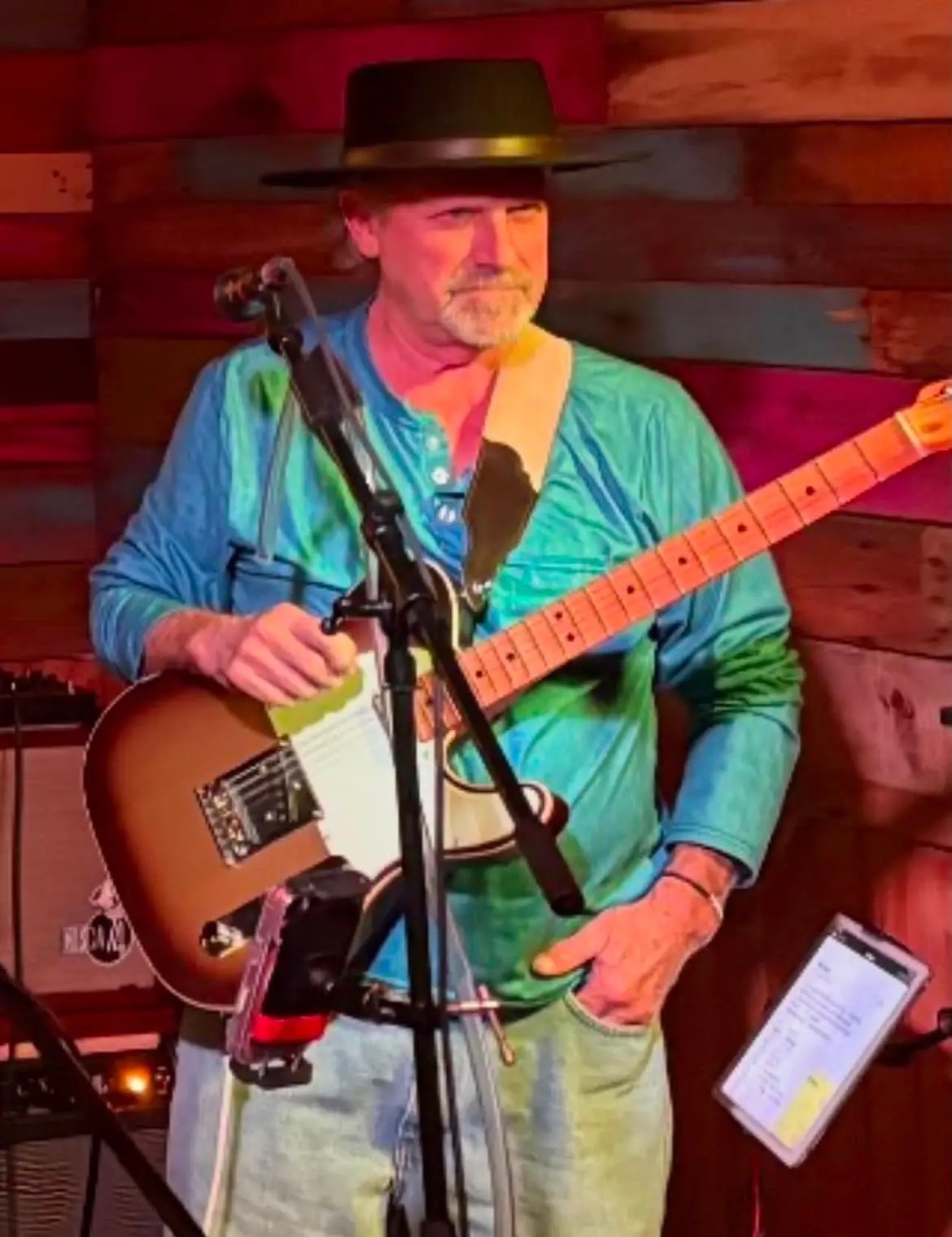 Bright Roads Band guitarist on stage under colored lights